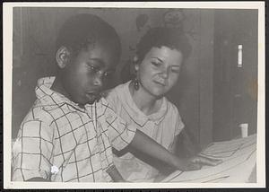 Boy making art with a teacher