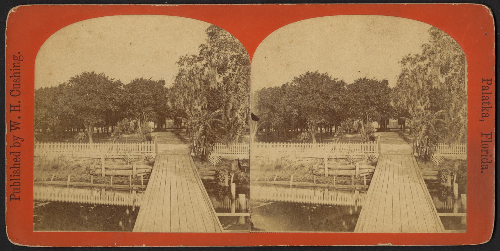 View looking from a boat landing, down a pathway that leads to trees and a building