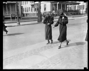 Two women hide their faces