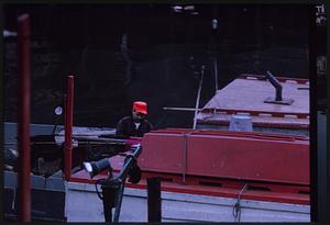 Man working on boat by pier