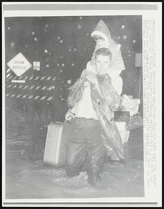 One man, driven from his home near the Industrial Canal and Poland Avenue, moves through swirling water 8/18 with his daughter and luggage. Rains from Hurricane Camille caused the levee to leak and send residents from their homes temporarily.