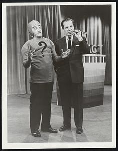 Al Kelly (left) explains his own double-talk version of a football classic while star comedian Joey Adams stands patiently by in a comedy skit from Back That Fact, ABC-TV’s new quiz program seen Thursdays, 9 to 9:30 p.m., EST.