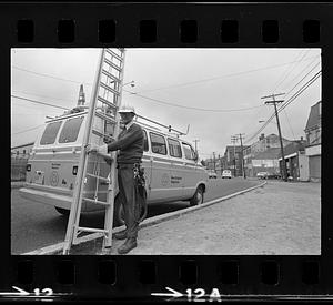 Man climbing pole near Customs House