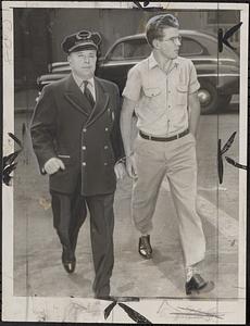 Prisoner William N. Elwell with Dept. Sheriff Eal Earle McAnnany on way to court from jail