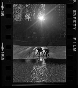 Boys play hockey on ice in Public Garden lagoon, Boston