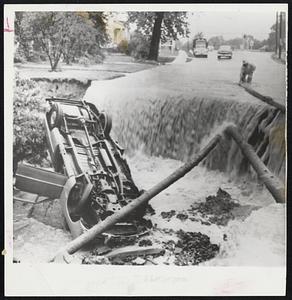 Highway Gives Way-A car parked at the side of the road in Agawam was hurled into a washout yesterday when the road collapsed from the flood condition created by the rainstorm.