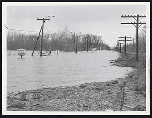 Several Feet of water covered Rte. 5, major north-south highway, in Northampton today as flood waters from swollen streams neared their peak. Note sign at left.