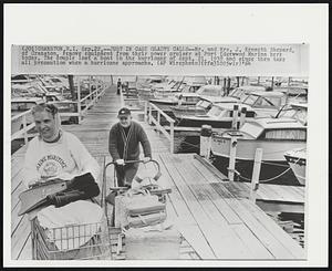 Just in Case Gladys Calls--Mr. and Mrs. J. Kenneth Shepard, of Cranston, remove equipment from their power cruiser at Port Edgewwod Marina here today. The couple lost a boat in the hurricane of Sept. 21, 1938 and since then take all precaution when a hurricane approachs.