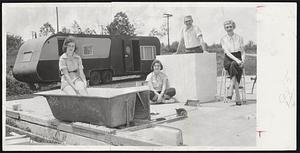 This Was A Home - The Dixon family of Uncatena Ave., Worcester, sit in what used to be their home before the tornado hit. In background is their temporary home - a government trailer. Left to right, Phyllis, 14; Mary, 13; James M. Dixon, and his wife, Mary.