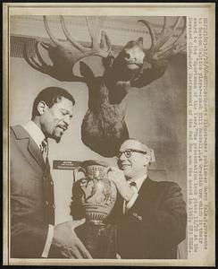 Boston: Sports illustrated publisher Garry Valk, R, presents to Boston Celtics player-coach Bill Russell, L, a Grecian urn which is their award to the "Sportsman of the Year." The presentation took place 12/18 at the Harvard Club. Carl Yastrzemski of the Red Sox won the award in 1967.