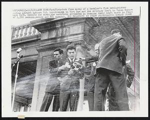 New York: Pacifists duck from spray of a heckler's fire extinguisher during protest against U.S. involvement in Vietnam and the military draft in Union Square here 11/6. Despite the spray the pacifists succeeded in burning their draft cards in front of 1,500 persons, police and FBI cameras.