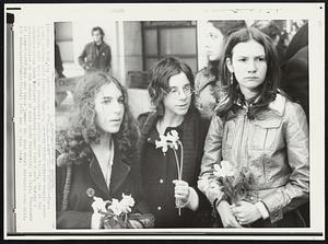 Mourners at Funeral of Kent State Student- Three young persons hold flowers Thursday as they stand outside chapel where services were held for 20-year-old Jeffrey Glenn Miller, one of the students slain when National Guardsmen opened fire Monday during a demonstration on the campus of Kent State University in Ohio. Thousands of long-haired boys and girls jammed the area where services were held.