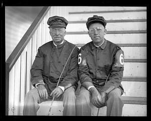 Two jockeys seated on stairs