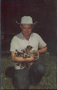 Mr. Bassett with an arm full of baby raccoons at the Bassett Animal Farm on Cape Cod