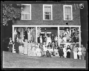 Group in costume pose in front of old house