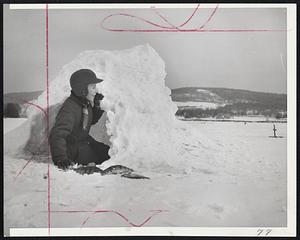 Igloo on Connecticut River - Jim Manley, 12, of Wallingford, Conn., vacationing near Bellows Falls, Vt., built this ice igloo to shelter him from wintry blasts while ice-fishing on the Connecticut River. Young Jim watches flag on "tip-up" at right. Bass in foreground proved the method works.