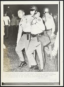 Trooper Injured -- A Maryland State Policeman helps his injured buddy after a rock-throwing confrontation with demonstrators at the University of Maryland in College Park.