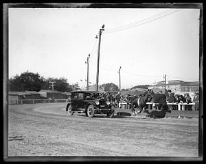 A horse runs past a car on a racetrack