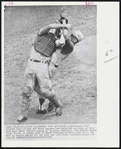 Double Duty on Pop-Up -- Cincinnati Reds catchers john Edwards and first baseman Don Pavletich collides as they both move under infield pop-up by St. Louis Cardinals stan Musial during first inning of todays game at Busch Stadium. Pavletich held on to the ball to retire Musial for the last out with bases loaded. St. Louis won 3-2.