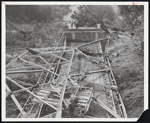 Dropped by raging water was this bridge o nRte. 44 ove the Farmington River in New Hartford, Conn. Notice how sides of bridge were flattened by water.