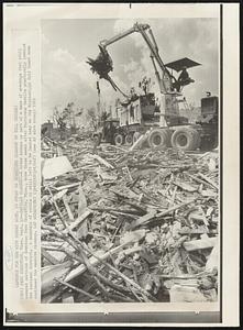 Camille Cleanup--A crane scoops up part of a mass of wreckage that still covered sections of downtown Pass Christian, Miss., some three weeks after Hurricane Camille practically leveled the business district. A mountain of rubble is still left to be hauled away as the Mississippi Gulf Coast area continued the massive cleanup.