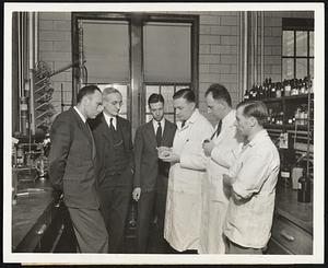 Chemists responsible for the latest successful synthesis of a vitamin examine one of the final stages in their work. The vitamin is pantothenic acid discovered to be present in all living tissues in minute amounts. (Left to right) Dr. Randolph T. Major, Director of the Merck Research Laboratories at Rahway, New Jersey, Dr. William H. Engels, Associate Director, Dr. Karl Folkers, Assistant Director, and the three men in white who accomplished the synthesis, Doctors J. Finkelstein, J.C. Keresztesy, and E. T. Stiller.