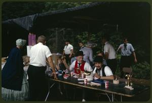 People in period dress helping at a food tent during the antique car rally BBQ