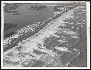 Humarock Beach In Scituate looked like this from the air yesterday, with the cottages nestled in deep snow along the spit and combers rolling in from the ocean in geometric patterns. Abnormally high tides have brought the water's edge to the very doorsteps of the cottages.