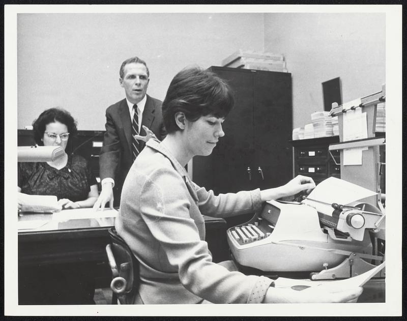 Last Minute Legislation was rushed through Secretary of State's office on the final day of the legislature. Miss Anne Danehy, in foreground, operates engrossing machine while Secretary Kevin White assists Miss Theresa Mustone, head administrative assistant, in proofreading the bills.