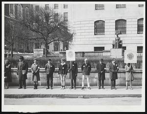 Good Friday Vigil-Members of the Society of Friends staged vigil outside the State House yesterday. They termed the demonstration a "Witness For Peace." In the background is the statue of Mary Dyer, the Quaker lady who was hanged as a witch back in the 17th century.