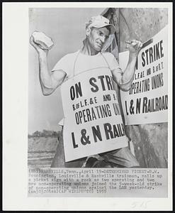 Determined Picket - B.W. Pennington, Louisville & Nashville trainman, nails up a picket sign with a rock as two operating and two new non-operating unions joined the 5-week-old strike of non-operating unions against the L&N yesterday.