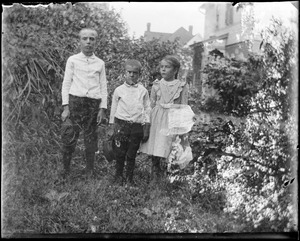 Fredrick, Robert and Mabel Wilhelm stand in a garden