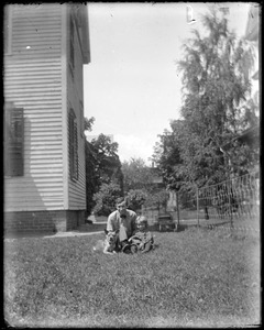 Man and child in a yard with a dog