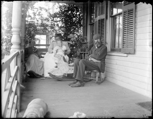 Two women, a child, and a man on porch