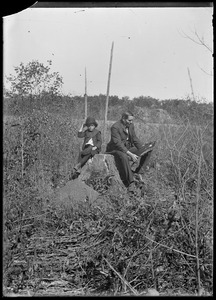 C.R. Wilhelm and his son Robert sitting on a stump