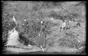 Unidentified man, woman and three children fishing in a stream