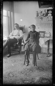 Unidentified man and girl seated in a parlor