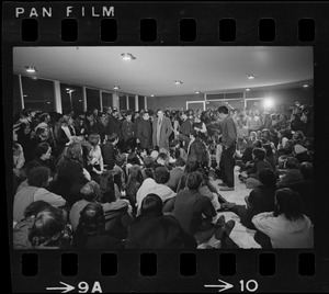 Brandeis University President Morris Abram talking to reporters and surrounded by students in the administration building during a sit-in