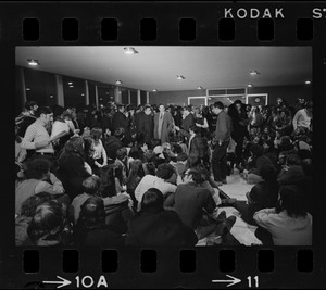 Brandeis University President Morris Abram talking to reporters and surrounded by students in the administration building during a sit-in