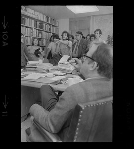 Dr. M.F. Millikan, Director of MIT Center for International Studies, sitting at desk and listening to SDS protesters