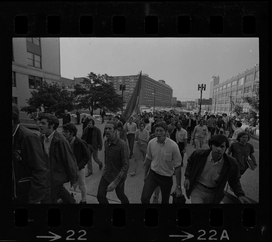 Chanting SDS members, armed with Viet Cong flags, approach main entrance of Massachusetts Institute of Technology protesting what they called "imperialist research"