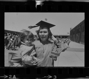 Boston University graduate holding a child