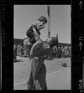 Boston University graduate holding child in the air