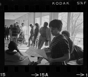 Student holds papers and speaks to a group inside the Bernstein-Marcus Administration Center during sit-in at Brandeis University