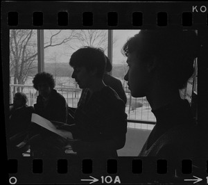 Student holds papers and speaks to a group inside the Bernstein-Marcus Administration Center during sit-in at Brandeis University