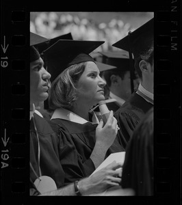 Graduate in audience with hand held fan at Brandeis University commencement