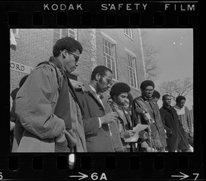 Student reads press release outside Ford Hall