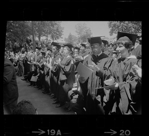 Brandeis University graduates sit in front row and clap during commencement exercises