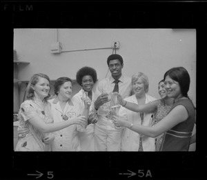 Group of people in lab coats and posing together while holding glass lab ware