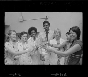 Group of people in lab coats and posing together while holding glass lab ware